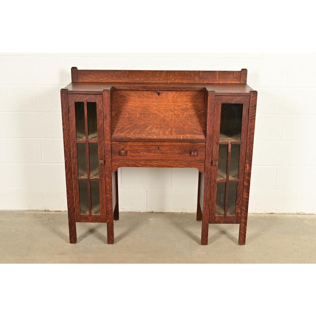 An outstanding antique Mission or Arts & Crafts side-by-side double bookcase cabinet with drop front secretary desk In the...