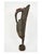 A tall carved wooden West African Senufo hornbill bird sculpture with a tuft of red fabric crowning the head, slender...
