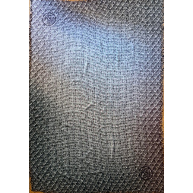 This very large Chanel scarf features the fashion house's iconic motifs: quilting, tweed, and large interlocking CC logos...