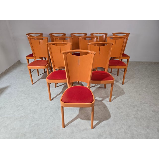 12 chairs from the French brand Baumann Paris circa 1970 Structure in orange lacquered wood and seat in red fabric. This...