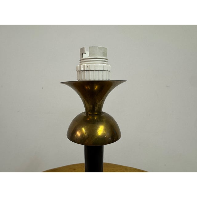 A delicate 1960s table lamp combining a light, architectural base with a softly decorative shade. Balancing mid-century...