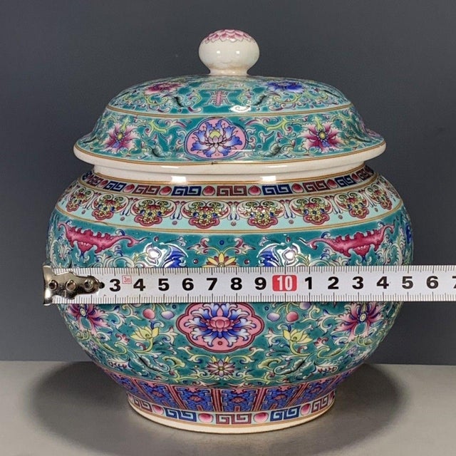 A vibrant Chinese porcelain covered jar featuring a bright turquoise ground. The jar is densely decorated with colorful...