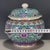 A vibrant Chinese porcelain covered jar featuring a bright turquoise ground. The jar is densely decorated with colorful...