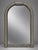 The mirror is distinguished by its rounded arch form, ribbed rope-like side members, and block-like gray tessellated stone...