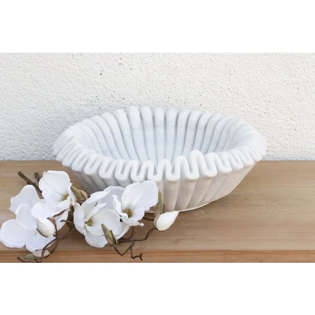 Carved from a single block of pristine white marble, the vessel has been meticulously hand-chiseled to create a continuous...