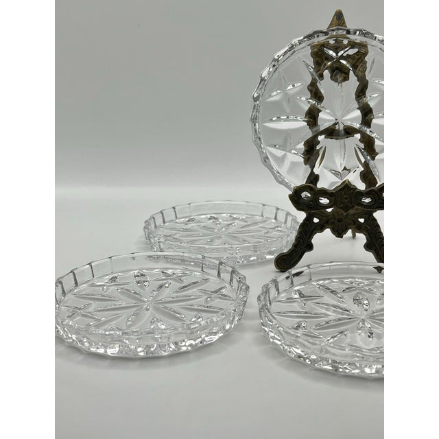 A set of vintage flute edged coasters decorated with a pattern of simple radiating faceted lines. Each coaster measures...