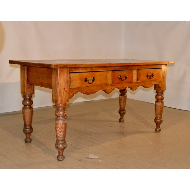 19th century pine harvest table made in the English region of Lancashire. The top is made up of planks and follows down to...