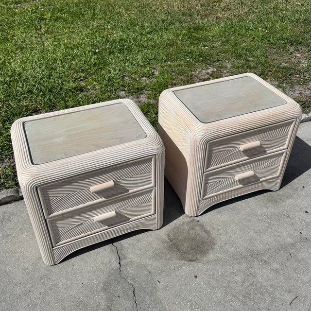 A stylish pair of vintage Boho Chic nightstands crafted in sculptural pencil reed with a soft neutral finish. The...