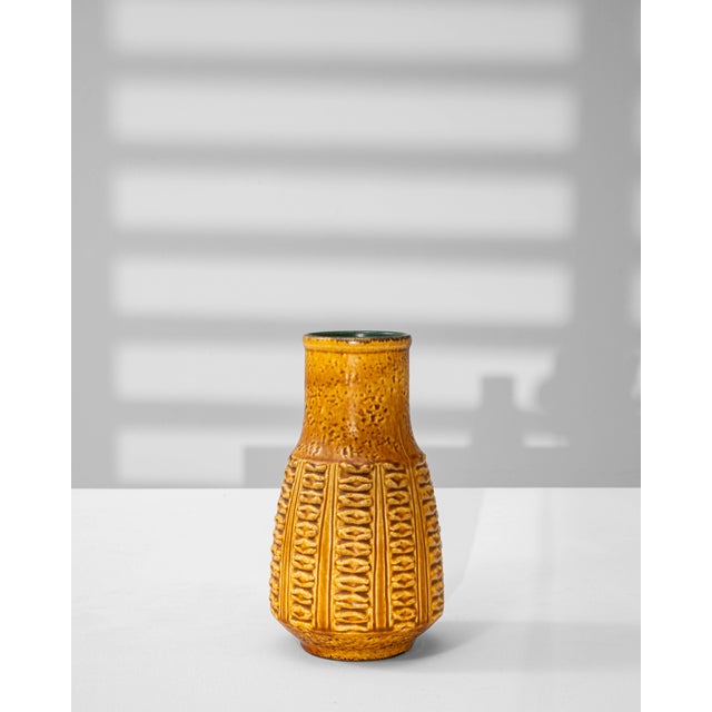 This 1960s German ceramic vase represents the distinctive craftsmanship of the W. Germany pottery era, celebrated for...