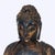 An antique carved wood seated Buddha statue, originating from the 19th century, features an ebonized finish with extensive...