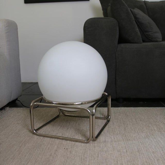 Vintage white opaline globe on a chrome base with a sleek design, evoking the codes of space age style while maintaining...