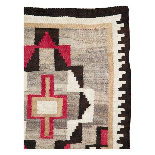A vintage American flatweave throw rug handmade by the Navajo tribe during the mid-20th century. Measures: 3' 1" x 5' 9".