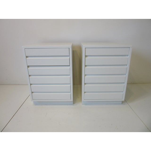 A pair of very well-crafted Mid Century creamy white nightstands with fluted fronts and three drawers to each. These...