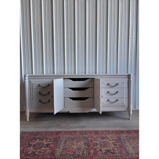 Elegant French Provincial–style dresser refinished in a soft white tone, highlighting its intricate carved detailing and...