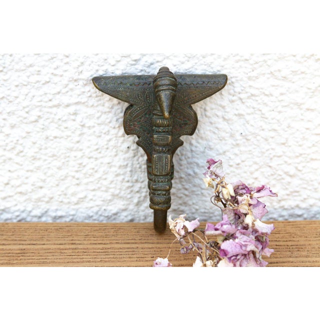 A robust utilitarian antiquity featuring a detailed geometric stem and a stylized architectural bud finial, carrying a...