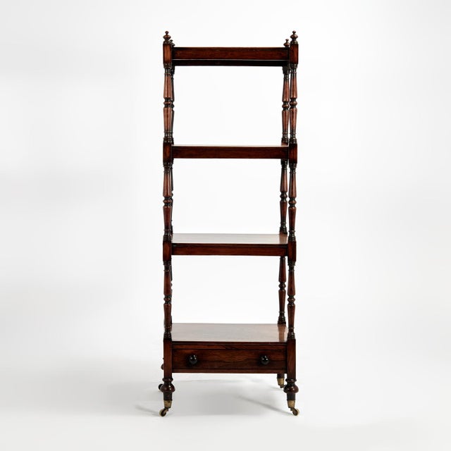 Standout 19th Century English stand handcrafted in rosewood in an elegant form with four tiers featuring turned finials on...