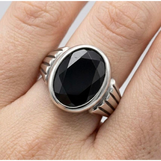 Bold, refined, and timeless, this striking ring features a deep black gemstone set in a sleek, polished silver...