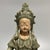 A vintage‑style Chinese Longquan celadon Guanyin statue in a relaxed seated pose. Detailed headdress and flowing carved...