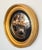 A fine English round or circular convex mirror from the Regency era, with a moulded gilt and ebonized frame.- the mirrored...