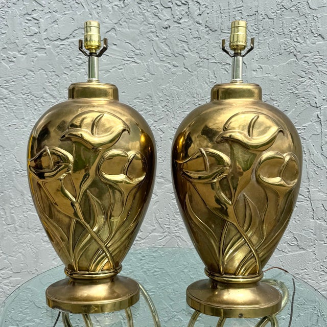 Elegant pair of Art Deco style table lamps featuring sculptural brass bodies adorned with stylized tulip relief motifs....