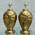Elegant pair of Art Deco style table lamps featuring sculptural brass bodies adorned with stylized tulip relief motifs....