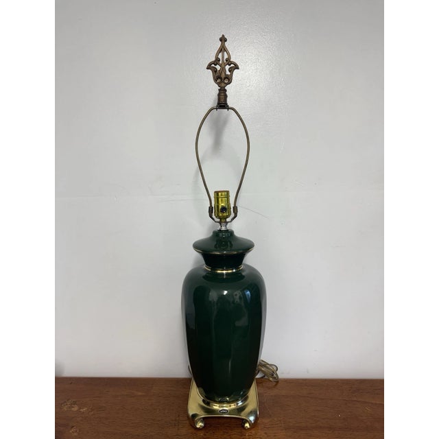 Vintage Mid-Century Hollywood Regency style green ceramic table lamp with elegant brass-tone base and accents. A timeless...