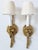 Pair of French Neoclassical style brass wall sconces with one light and silk pleated shades. The sconces feature a tassel...