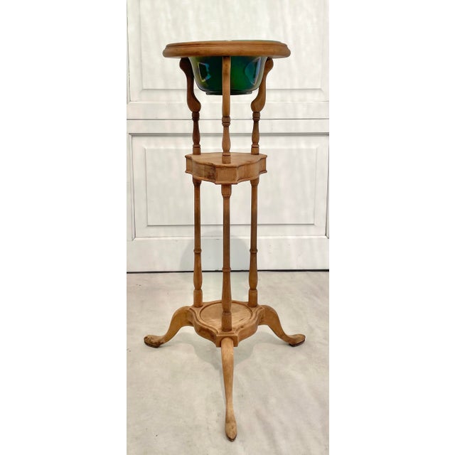 This early 20th century jardinière stand pairs a beautifully aged wooden plant stand with a vibrant green glazed pottery...