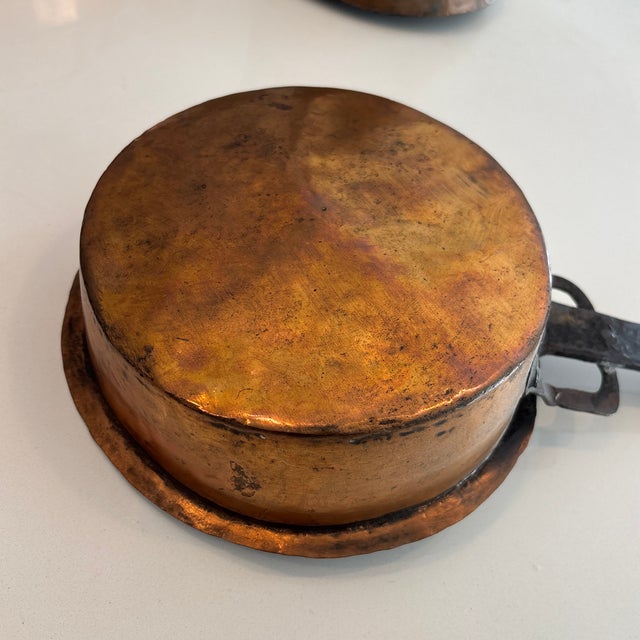This is likely an antique hand-forged copper pan with a wrought iron handle, potentially dating back to the 1800s....