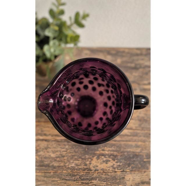 Striking vintage art glass pitcher in a rich amethyst-purple hue, featuring an all-over raised hobnail texture,...