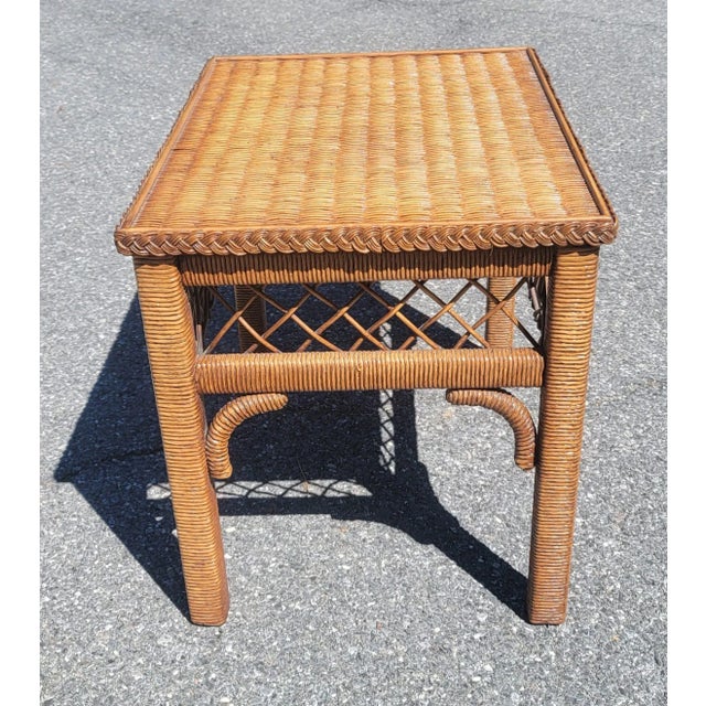 Gorgeous bohemian style rectangular side table by Henry link. Table features woven wicker and rattan frame with a glass...