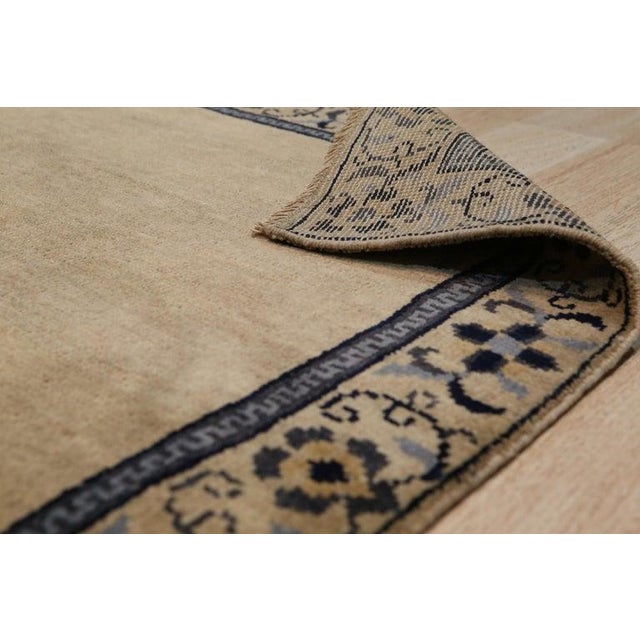 This hand knotted pile rug is crafted from wool and features a primary color palette of ivory, beige, cream, and white....