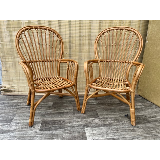 A Pair of Rattan Fan Back Lounge Chairs in the Franco Albini's Style. Circa 1980s natural rattan with woven detailing. The...