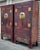 A pair of massive wooden two-door cabinets. The scale is accentuated by oversized round bronze escutcheons and pulls. The...