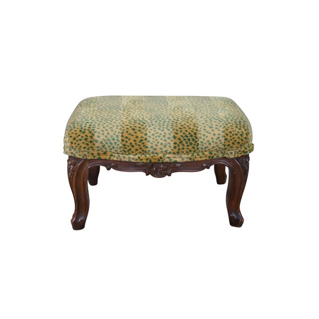 This antique Louis XV style footstool features a hand-carved solid walnut base showcasing a warm, rich natural wood grain...