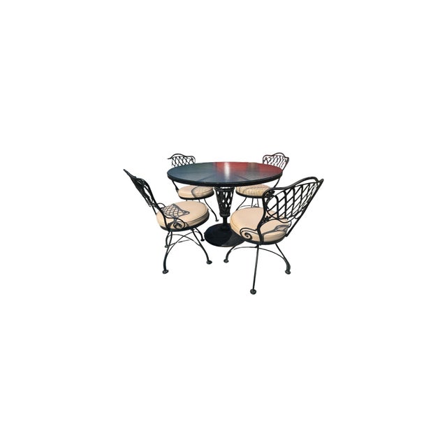 Vintage Woodward wrought iron patio set. Glass top table with 4 chairs. Suitable for covered patio with heavy duty vinyl...