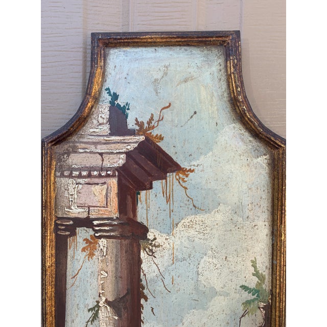 A distinctive Italian capriccio landscape, painted in oil on a shaped panel and presented in a softly worn giltwood frame....