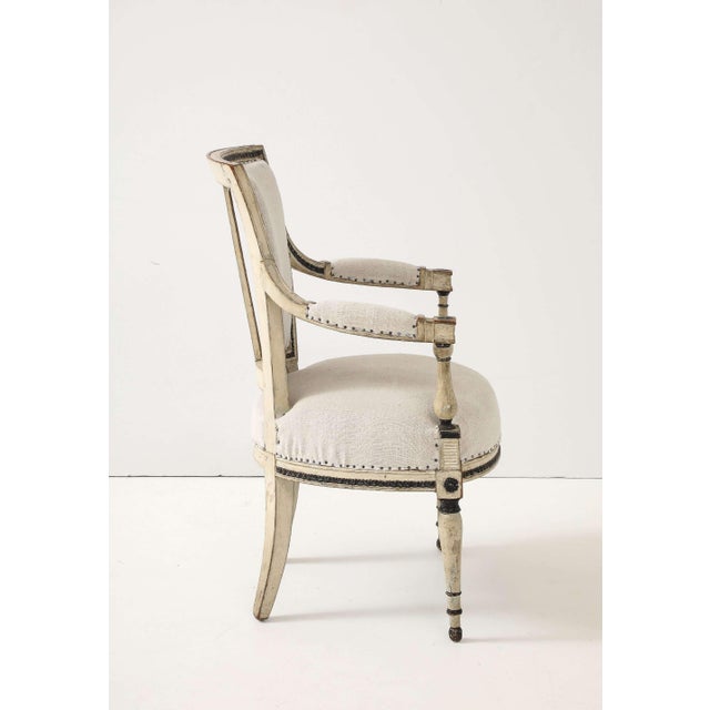 A crisp duo of late-18th/early-19th-century Directoire armchairs from France, hand-painted in an aged ivory hue with...