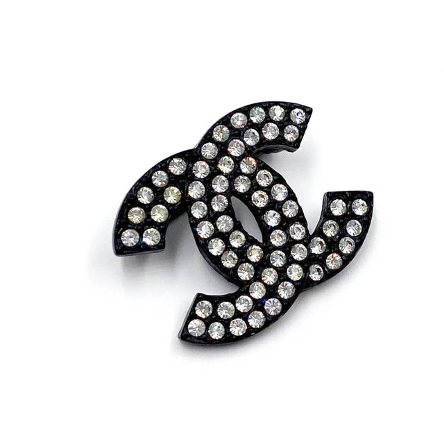 This is part of Chairish’s Costume Jewelry assortment. Chanel Vintage Black CC Crystal Small Brooch *Marked 02 *Made in...
