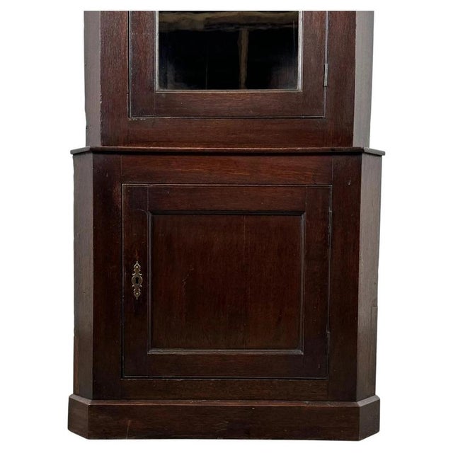 A handsome 19th century English corner cabinet, finely constructed from solid oak and displaying a deep, warm patina with...