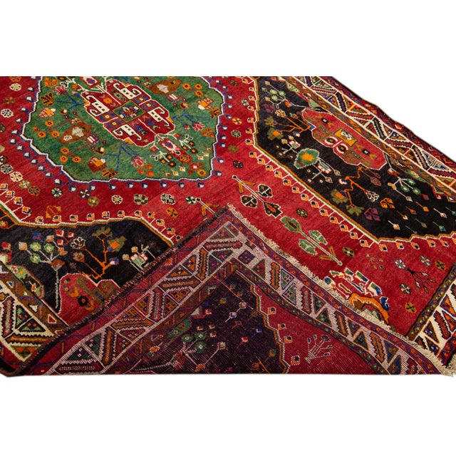 Beautiful Antique Persian Shiraz handmade wool rug with an all-over red and green field. This piece has multi-color...