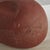 An Abstract, organic form terracotta clay sculpture featuring a smooth, red surface with natural aged patina. Delicately...