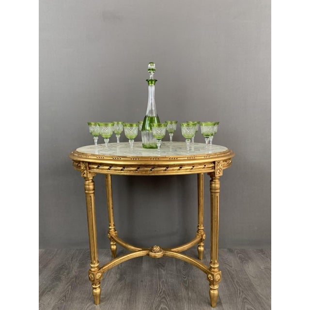 Set of 11 green-tinted crystal glasses and a matching decanter, 20th century. We present an exquisite tableware set, ideal...