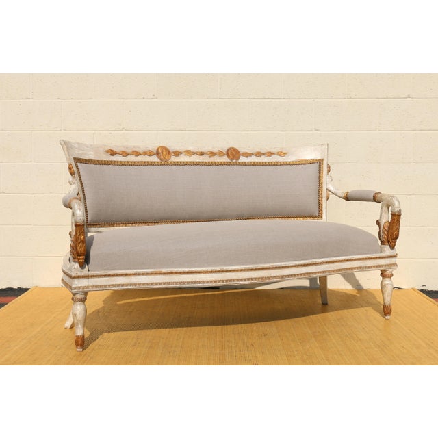 Wonderful painted and parcel gilt Empire sofa with medallions heads on the back, uprights modeled as swan heads in the...