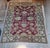 0versized hand-knotted Indian Agra rug featuring a deep burgundy field framed by a soft sage green border. The rug...