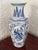 Large blue and white porcelain vase with a faceted body and tall flared neck. The panels show alternate between figures...