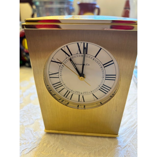 An elegant vintage Tiffany & Co. brushed brass desk alarm clock dating to the 1970s, featuring a distinctive half-moon...