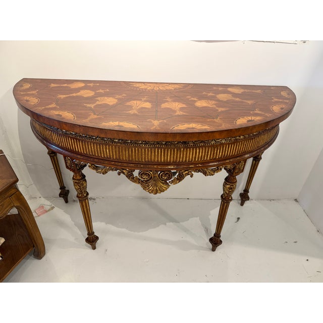 Stunning demilune (half-moon) console table featuring an elaborately inlaid marquetry top with fan, shell, and foliate...