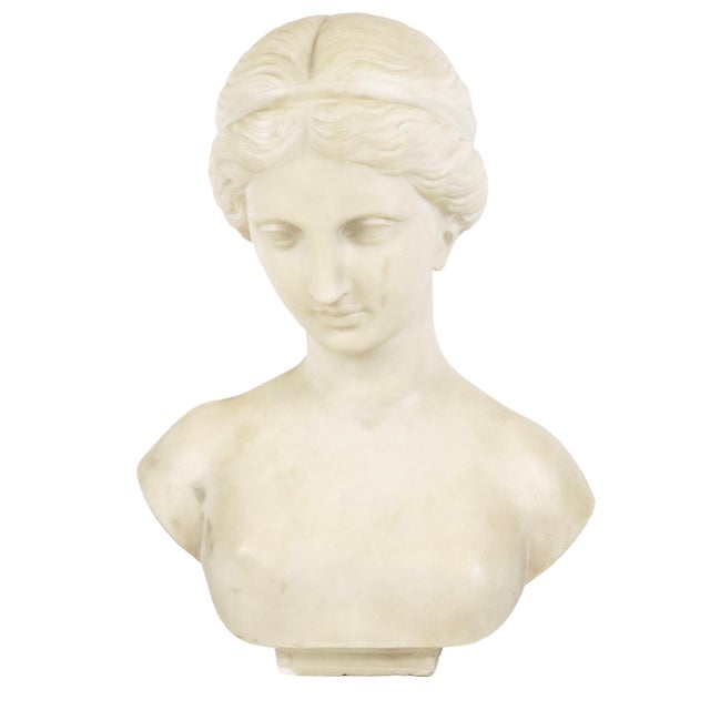 Italian Neoclassical Grand Tour Carved Marble Bust of a Young Woman. The figure is presented in an introspective pose, her...