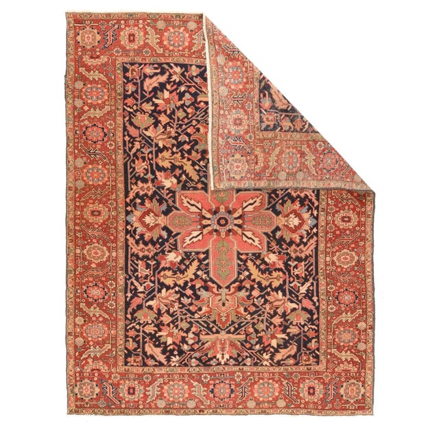 A broad madder red strip-style border of multicolor rosettes and doubly bent leaves frames the rare dark blue field...